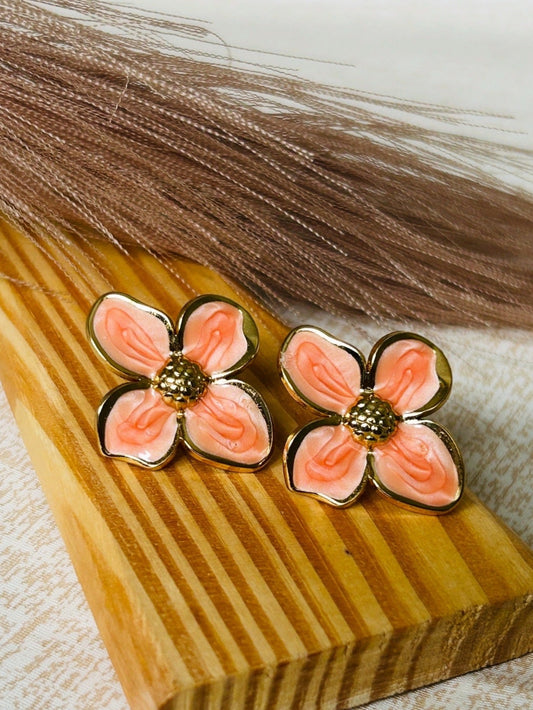 Floral earrings on a wooden block with a neutral background