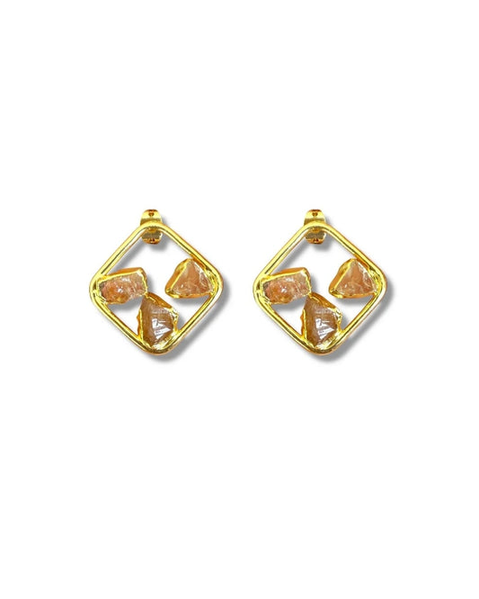 Gold earrings with orange gemstones on a white background