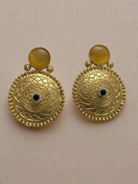 Gold earrings with circular designs and a central gemstone